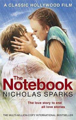 The Notebook by Nicholas Sparks movie version book cover with a White woman kissing a White man in the rain