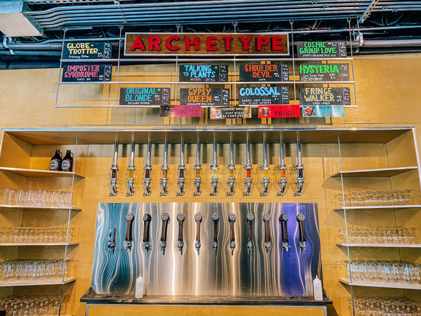 Archetype Brewing West Asheville with picture of beer taps surrounded by shelves of clean glasses on either side